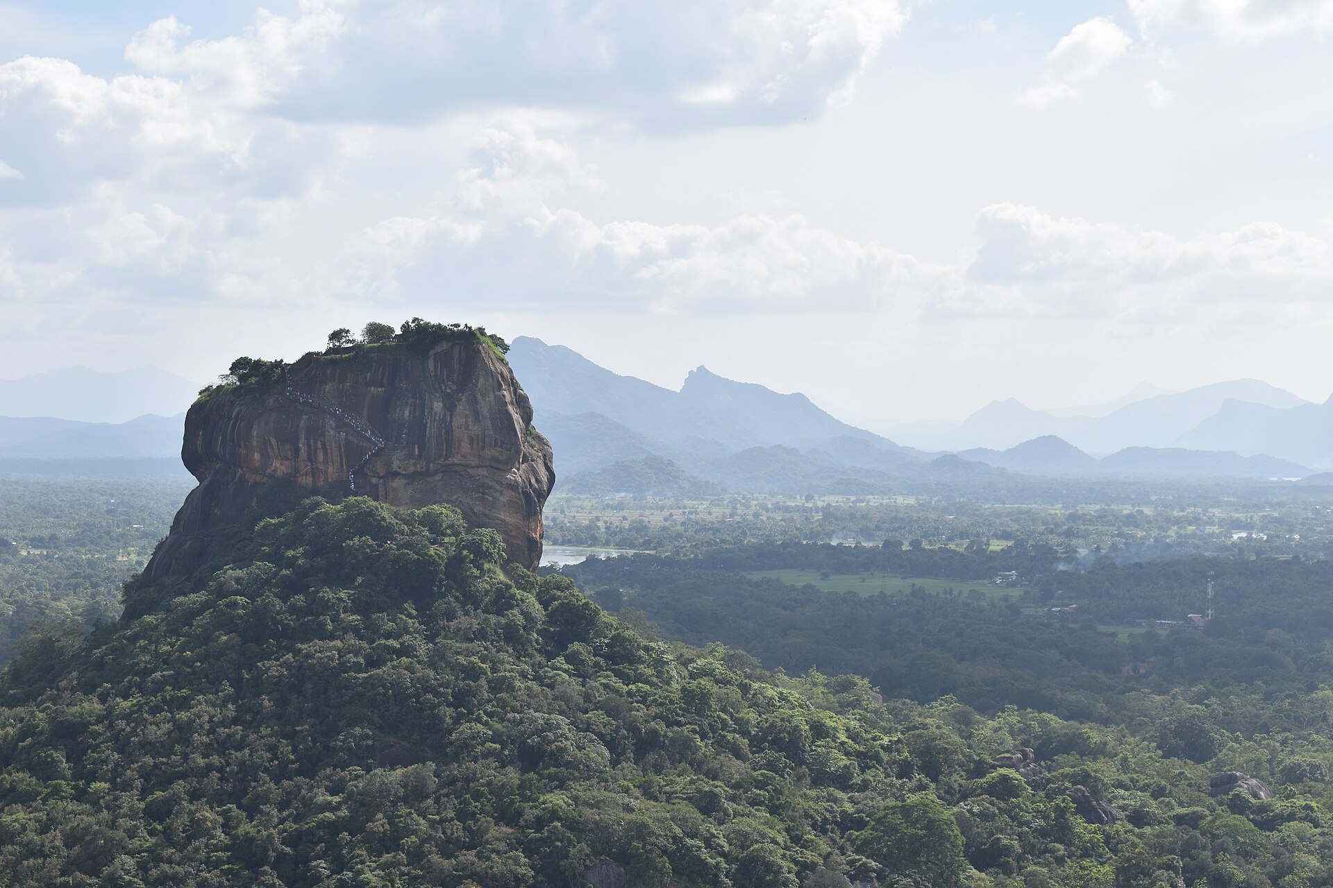 Sigiriya rock fortress rising above the green forest, seen from the top of Pidurangala Rock in Sri Lanka.