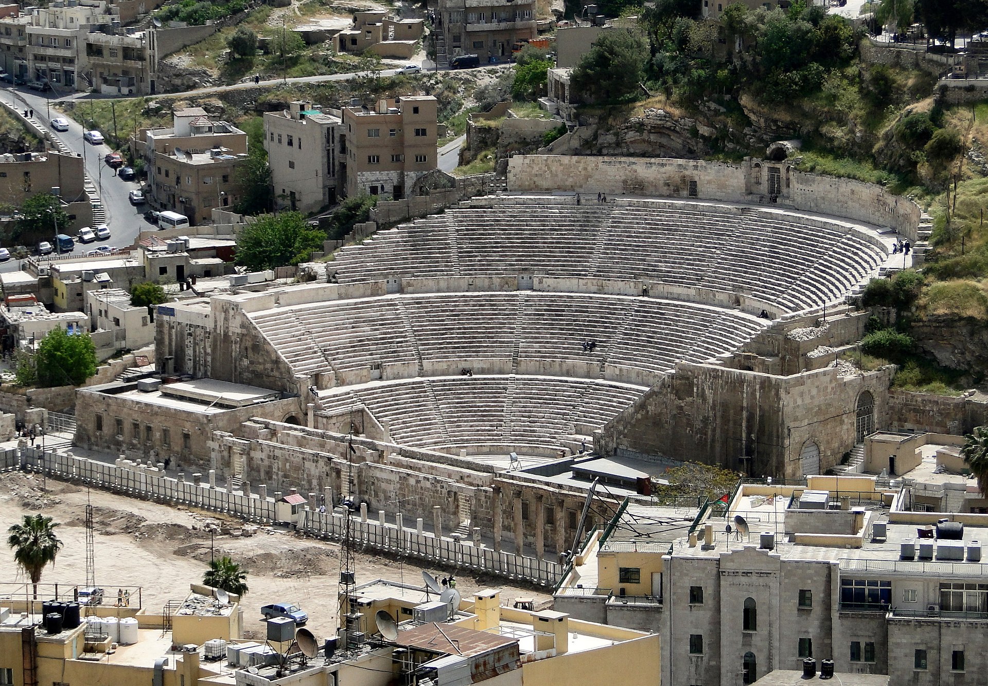 The Roman Theatre of Amman set into the hillside among the city's stone buildings.