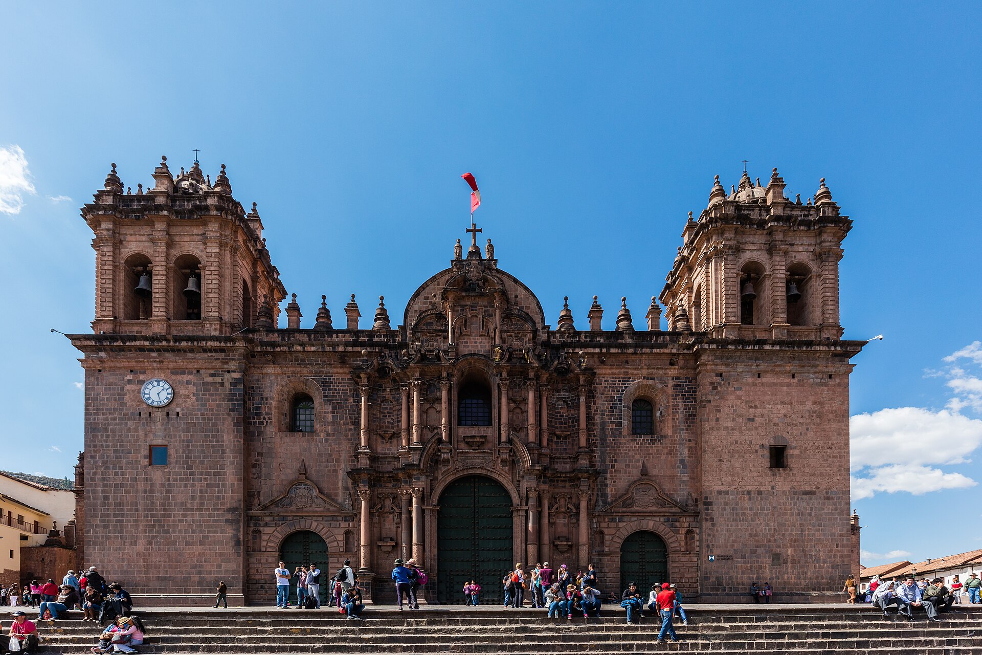 The stone facade of Cusco Cathedral on the Plaza de Armas under a clear blue sky.